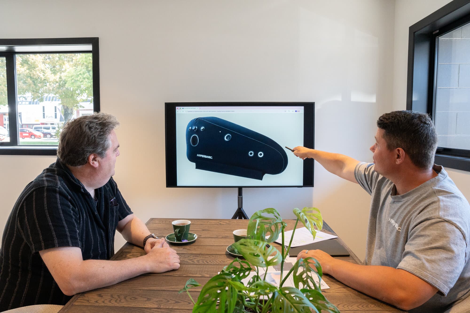 Two people discussing hyperbaric chamber options on screen
