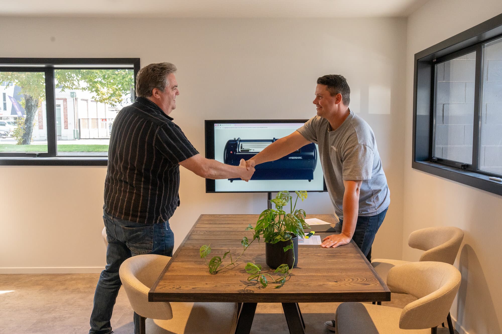 A warm handshake between Callum and a client after a consultation